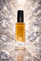 Perfume bottle labeled 'White Diamond' surrounded by diamonds on a reflective surface